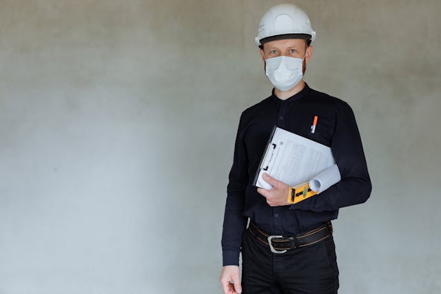a%20contractor%20in%20a%20mask%20and%20hard%20hat%20holding%20a%20clipboard a%20contractor%20in%20a%20mask%20and%20hard%20hat%20holding%20a%20clipboard